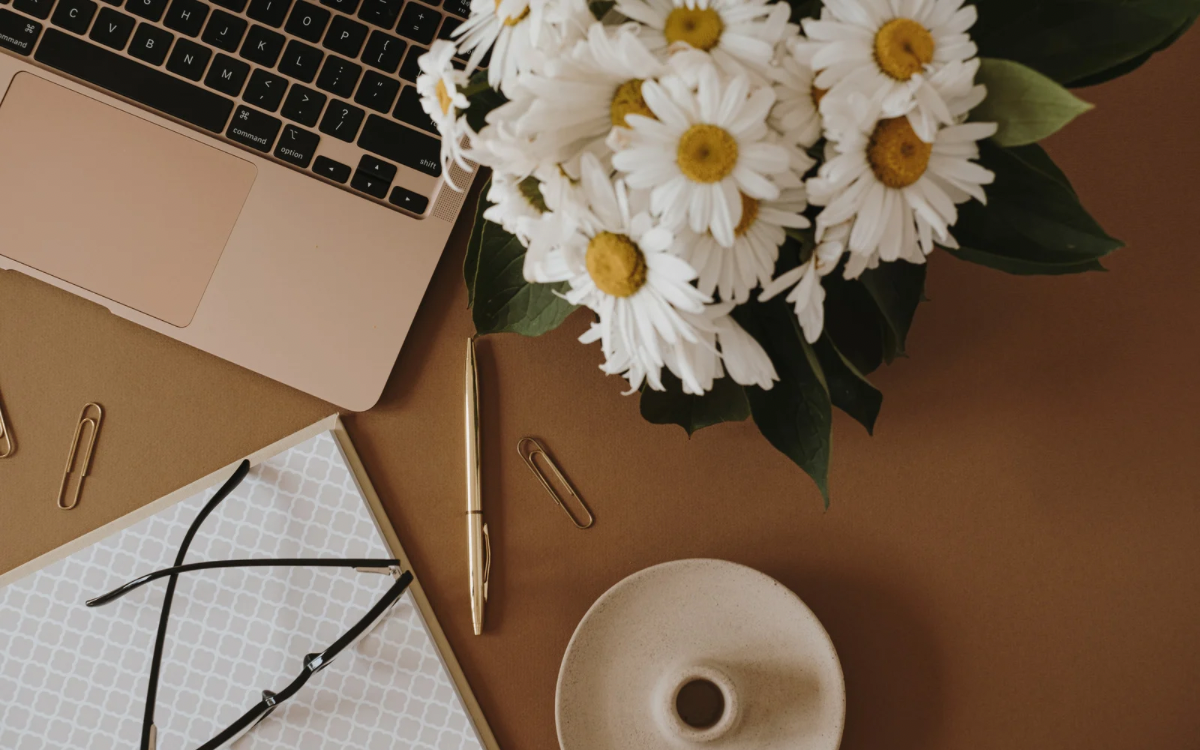 Image of laptop, daisy flowers and stationary